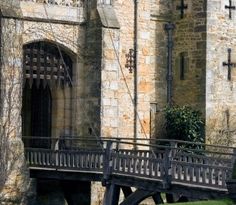 an old stone building with a bridge going across it