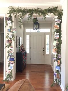 a hallway decorated for christmas with garland and photos on the wall, along with an entry way