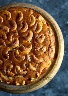 a close up of a cake in a wooden bowl on a table with blue background