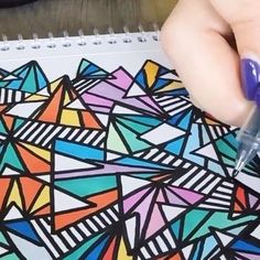 someone is drawing on a notebook with markers