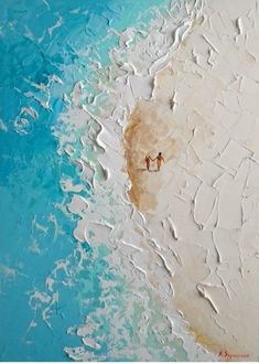 two people are walking on the beach with blue water and white sand in the background