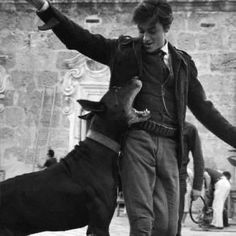 a man is playing with his dog on the street