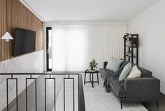 a living room filled with furniture and a flat screen tv on top of a wooden wall