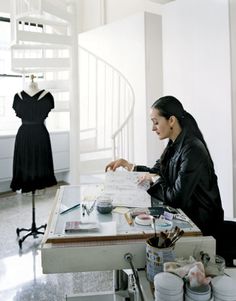 a woman sitting at a table in front of a dress