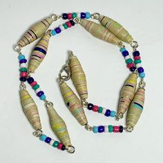 multicolored beads and silver chain necklace on white surface