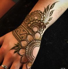 a woman's hand with henna tattoos on it