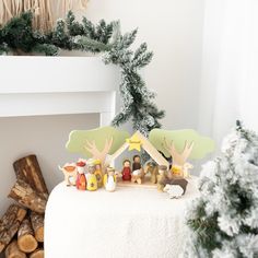 a nativity scene is displayed in front of a fireplace