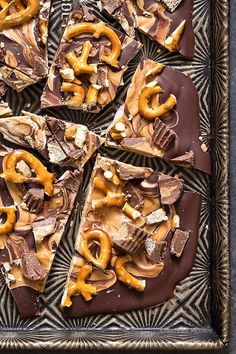 a chocolate dessert with pretzels and marshmallows on top, cut into squares