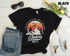 "This Nature Awaits TShirt is perfect for any adventure lover! Makes a great shirt for camping, hiking, vacationing, and enjoying the outdoors! **DETAILS** This Bella Canvas 3001 unisex t-shirt is soft and lightweight, the comfiest shirt you will own! It's comfortable and flattering for both men and women. - Unisex sizing please refer to sizing chart in listing photos - 100% combed and ring-spun cotton  - Medium fabric weight **PRINTING** - DTG (Direct To Garment) Printed  **CARE** - Machine wash: cold - Hang to dry preferred. Tumble dry low - Do not iron directly on print **SHIPPING** - Products are shipped after 2-7 days in production **POLICIES** All items are made when you place your order. For this reason we are unable to accept returns / exchanges unless there's a defect in the item Black Hiking T-shirt With Letter Print, Black Letter Print T-shirt For Hiking, Black T-shirt For Hiking With Letter Print, Black Relaxed Fit T-shirt For Outdoor Activities, Casual Black T-shirt For Hiking, Camping Clothes, Mountain Tshirt, Camping Outfits, Comfy Shirts