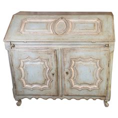 an old white painted wooden cabinet with ornate carvings on the front and sides, isolated against a white background