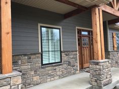 a house with stone pillars and wooden doors