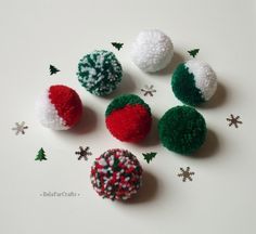 four different colored balls with sprinkles and snowflakes around them on a white surface