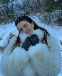 a woman wearing black gloves and a white fur coat