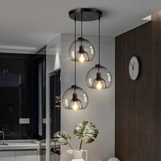 a dining room table that has some lights hanging from it's ceiling above it