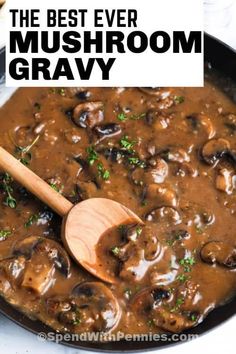 mushrooms and gravy in a skillet with a wooden spoon on the side