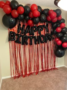 a birthday party with balloons and streamers in the shape of a happy birthday sign