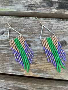 Gold, purple, and green czech seed beads have been hand woven onto a stainless steel triangle to create a long fringe that moves with you. Perfect for your Mardi Gras outfit! Each bead has been touched by my hand multiple times, a lot of time and energy goes into each piece. Please note that color/tone may differ in person due to monitor brightness and other settings. Adjustable Triangle Beaded Earrings, Bohemian Triangle Beaded Earrings, Adjustable Triangle Beaded Jewelry, Adjustable Triangular Beaded Jewelry, Mardi Gras Outfits, Hippie Style, Colour Tone, Mardi Gras, Beaded Earrings