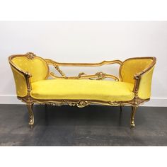 a yellow couch sitting on top of a hard wood floor next to a white wall