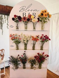 flowers are arranged in vases on a shelf for sale at a flower shop or florist shop