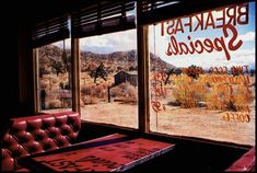 a window with the words breakfast specials written on it in front of a desert scene