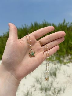 This coastal inspired necklace features a white and gold chain, and is finished with a colorful enamel starfish charm in the color of your choice. This 16 inch necklace closes using a gold lobster claw.  If you do decide to wear your jewelry to the beach, consider slipping it off and stowing it in a secure place before you head into the water. If you like this, you'll love the matching earrings! Check it out here on my shop! https://www.etsy.com/listing/1724960232/coastal-inspired-starfish-earrings-beach?click_key=8ccdb0f39da7ad646401ef427358bf5007cf2d4e%3A1724960232&click_sum=63d9e728&ref=shop_home_active_1 All orders will be packaged in a small box along with bubble packaging for safest of travels to you! Thank you for supporting my small business! - Olivia from The Sandy Poppy <3 Starfish Necklace With Lobster Clasp For Vacation, Ocean-inspired Starfish Beaded Necklaces, Adjustable Necklace With Starfish Charm, Ocean-inspired Starfish Charm Beaded Necklace, Beaded Starfish Necklace For Vacation, Starfish Shaped Beaded Necklaces For Gift, Starfish-shaped Beaded Necklace For Gift, Starfish Shaped Beaded Necklace For Gift, Starfish Charm Necklace With Round Beads For Gifts