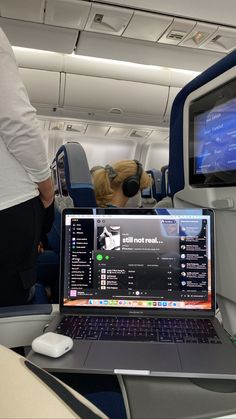 a laptop computer sitting on top of an airplane seat