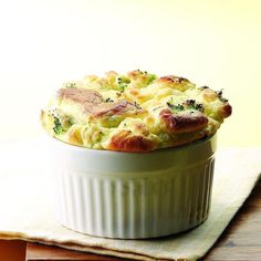 a casserole dish with broccoli and cheese in it on a table