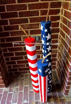 two american flags are tied to poles in front of a brick wall