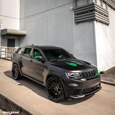 a gray jeep parked on the side of a building