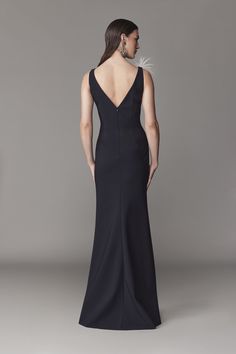 a woman in a long black dress with an open back