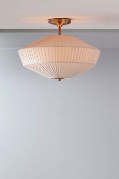 a light fixture hanging from the ceiling in a room with white walls and flooring