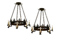 two chandeliers with candles hanging from the bottom and one on each side,