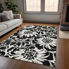 a black and white rug is in front of a window with a couch, chair, and fireplace