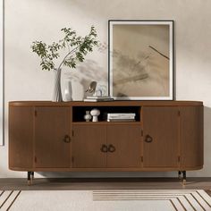 a large wooden cabinet sitting in a living room next to a painting on the wall