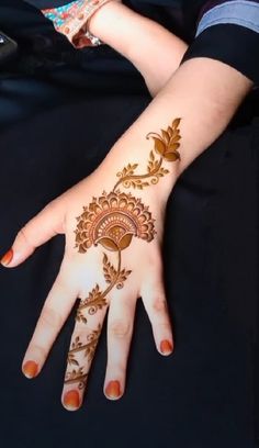 a woman's hand with henna tattoos on it