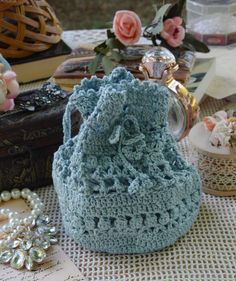 a blue crocheted purse sitting on top of a table next to other items