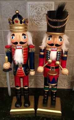 two nutcrackers are standing next to each other in front of a wall