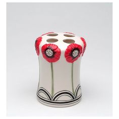 a white vase with two red flowers on the top and one black flower in the middle