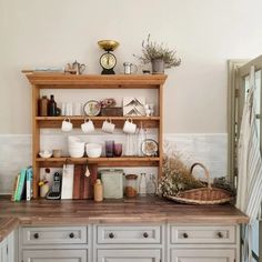 a kitchen with white cabinets and wooden shelves