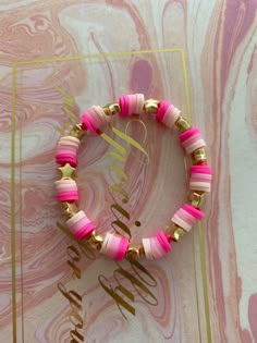 two pink and gold bracelets sitting on top of a marble surface with the word monogram