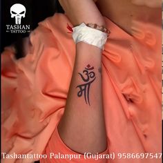 a woman with a tattoo on her arm and wrist is sitting in an orange dress