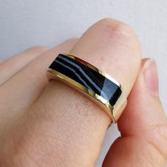 A solid and substantial gold band, set with a polished, elongated piece of banded agate to the face, with full British hallmarks for 9ct gold, dated 2002. A great band for stacking, suitable for both men and women.Hallmarked as 9ct gold, dated Sheffield 2002.Maker's mark "MD".The face of the band measures approximately 6.4mm wide.The shank measures approximately 4.5mm wide.The approximate weight is 6.1 grams.Please note that the antique ring box pictured is for display purposes only. Thank you.R Classic Agate Jewelry With Polished Finish, Yellow Gold Agate Ring For Anniversary, Anniversary Agate Rings With Polished Finish, Formal Yellow Gold Agate Rings, Gold Agate Rings For Anniversary, Gold Agate Rings With Polished Finish, Gold Agate Jewelry With Polished Finish, Antique Ring Box, Gold Pearl Ring