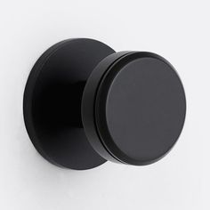 an image of a black knob on a white wall