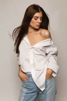 a woman with long hair wearing jeans and a white shirt is posing for the camera