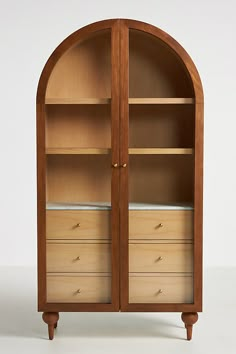 an arched wooden bookcase with drawers