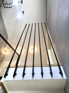 an image of a stair case with black railings and lights on the wall behind it