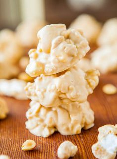 some cookies are stacked on top of each other with white frosting and peanuts scattered around them