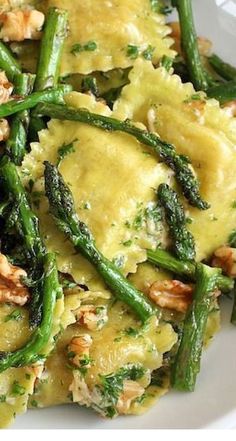 a white plate topped with pasta and asparagus