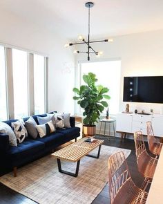 a living room filled with furniture and a flat screen tv on top of a wooden table