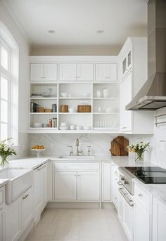 a kitchen with white cabinets and marble counter tops